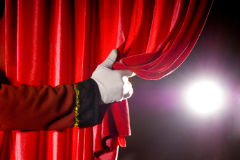 gloved hand pulling back curtain